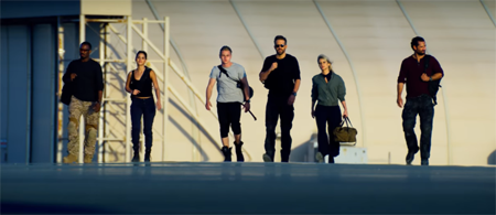6 Underground cast walking towards the camera in a flat airport type surface.